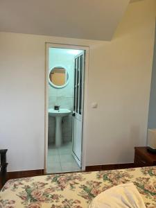 um quarto com uma cama e uma casa de banho com um lavatório em Casa BB&Djassi em Ponta do Sol