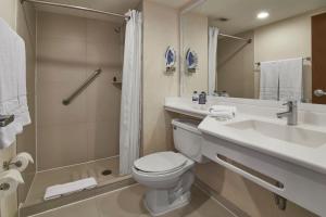 a bathroom with a toilet and a sink and a shower at City Express by Marriott Puebla Angelopolis in Puebla +17 photos