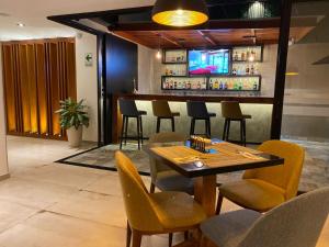 a restaurant with a bar with chairs and a table at Grau Business Hotel in Piura