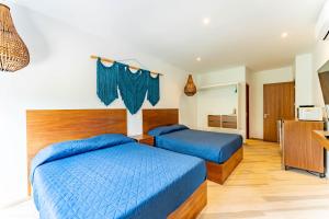 ein Hotelzimmer mit 2 Betten und einer Küche in der Unterkunft ANANA Yaaxlum 105 s in Tulum