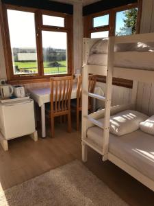 a room with a bunk bed and a table and a tableablish at Quirky cosy rural hideaway in Swindon