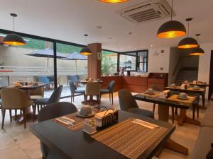 um restaurante com mesas e cadeiras e uma cozinha em Grau Business Hotel em Piura