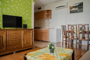 a living room with a tv and a table and chairs at Vacation home ROT Ohrid in Ohrid
