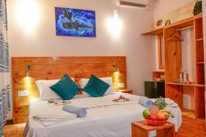 a bedroom with a bed with a bowl of fruit on it at Thulusdhoo Inn in Thulusdhoo