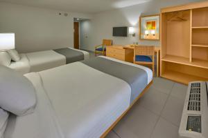 a hotel room with two beds and a desk at City Express by Marriott Lazaro Cardenas in Lázaro Cárdenas