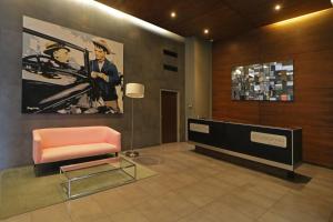 a lobby with a chair and a painting on the wall at City Express Suites by Marriott Santa Fe in Mexico City