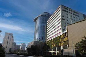 um edifício de vidro alto numa cidade em City Express Suites by Marriott Santa Fe em Cidade do México