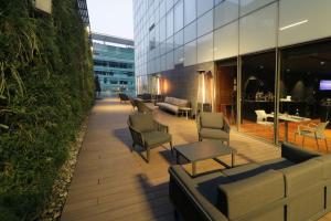 a patio in a building with chairs and tables at City Express Suites by Marriott Santa Fe in Mexico City