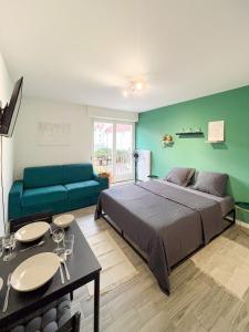 a bedroom with a large bed and a couch at Studio Le Maréchal - Près frontière et Netflix in Huningue +17 photos
