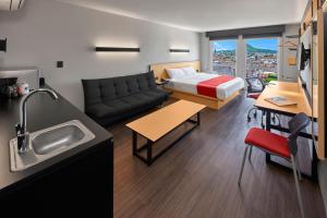 um quarto com uma cama e uma cozinha com um lavatório em City Express by Marriott Tepic em Tepic