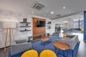 a living room with couches and a tv at City Express by Marriott Monterrey Lindavista in Monterrey