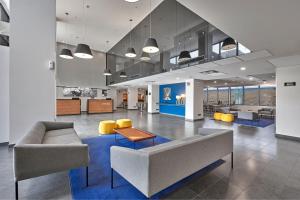 a lobby with a couch and chairs and a table at City Express by Marriott Monterrey Lindavista in Monterrey