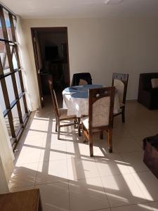 a dining room with a table and chairs on a tiled floor at Coco's house in Sucre