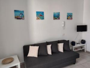 salon z kanapą i zdjęciami na ścianie w obiekcie Endless Summer w mieście Fontane Bianche