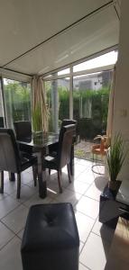 een woonkamer met een glazen tafel en stoelen bij Rêve de Bisca Appartement spacieux avec jardin privatif piscine et parking privés in Biscarrosse