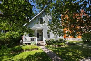 a white house with a porch and a yard at Small Suite STEPS from Oberlin in Oberlin