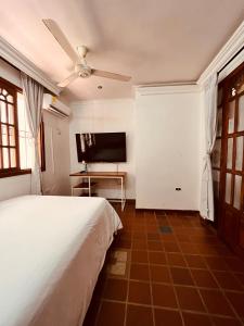 a bedroom with a bed and a flat screen tv at Casa Isabelita in Mompos