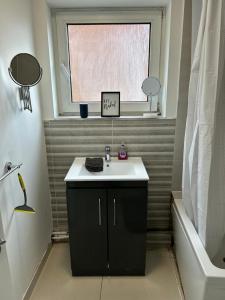 baño con lavabo y ventana en 4 Bedroom Flat In Watford en Leavesden Green