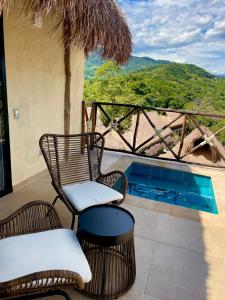 a patio with two chairs and a swimming pool at Hotel Alto de Pajas Boutique by H&R in Villeta