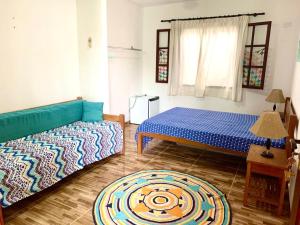 sala de estar con 2 camas y alfombra en Recanto Da Ursa en Búzios