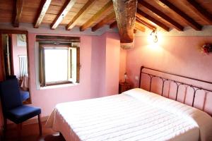 a bedroom with a bed and a blue chair at Tuscany Villa Chianti Hills - Villa Oliveta in Loro Ciuffenna