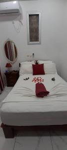 um quarto com uma cama branca com flores em Damech Apparts em Iaundé