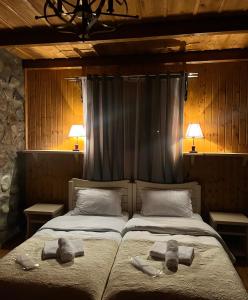 two beds in a room with towels on them at Inn Harmony in Stepantsminda