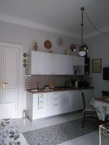eine Küche mit weißen Schränken und einem Tisch im Zimmer in der Unterkunft La Falconiera in Vigevano
