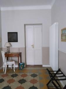 Zimmer mit einem Schreibtisch, einem Stuhl und einer Tür in der Unterkunft La Falconiera in Vigevano