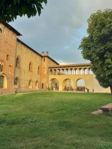 ein großes Backsteingebäude mit einem Grasfeld davor in der Unterkunft La Falconiera in Vigevano
