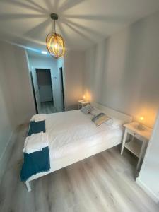 un letto bianco in una stanza con due tavoli di Venerable Carabantes Soria Centro con Garaje a Soria