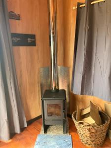 a wood stove in a room with a basket at El banzai in Punta Del Diablo