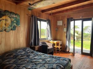 1 dormitorio con cama, silla y escritorio en El banzai en Punta del Diablo