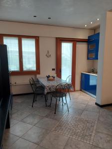a kitchen with a table and chairs in a room at INDIGO APARTMENT Cavallino Treporti in Cavallino-Treporti