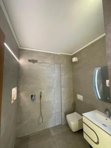 a bathroom with a shower and a toilet and a sink at Aquamarine Dreams Apartments in Beach of Durres 150 m from Sea in Durrës