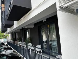 - un balcon avec des chaises et des voitures garées dans un parking dans l'établissement MARINA BOUTIQUE Costinesti, à Costinesti