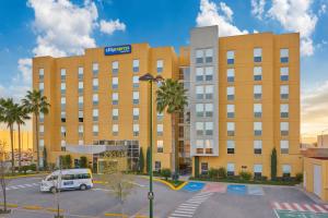 a building with a van parked in a parking lot at City Express by Marriott Torreon in Torreón