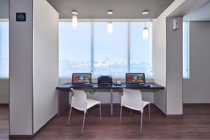 einen Schreibtisch mit zwei Laptops und zwei Stühlen in einem Büro in der Unterkunft City Express Junior by Marriott San Luis Potosi Carranza in San Luis Potosí