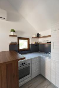 a kitchen with white cabinets and a window at Apart 31 in Cetinje