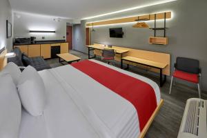 a hotel room with a large bed and a kitchen at City Express by Marriott Mexicali in Mexicali