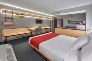 ein Hotelzimmer mit einem Bett, einem Schreibtisch und einem Computer in der Unterkunft City Express by Marriott Monterrey Santa Catarina in Monterrey