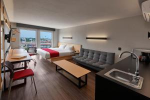 a hotel room with a bed and a couch at City Express by Marriott Tampico Altamira in Tampico