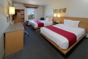 a hotel room with two beds and a desk at City Express by Marriott Nuevo Laredo in Nuevo Laredo