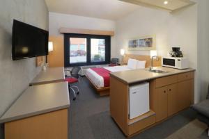 a hotel room with a bedroom with a bed and a sink at City Express by Marriott Nuevo Laredo in Nuevo Laredo