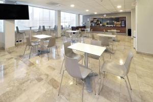 a cafeteria with tables and chairs and a flat screen tv at City Express by Marriott Nuevo Laredo in Nuevo Laredo
