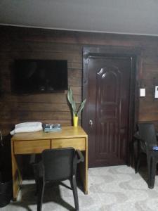 Habitación con mesa de madera y puerta de madera. en AO EO little wooden house honeymoon suite, en Santiago de los Caballeros