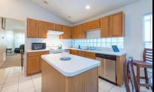 a kitchen with wooden cabinets and a white counter top at Orlando getaway in Orlando