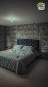 a large bed in a bedroom with a brick wall at Casa Campesina La Fagua in La Calera