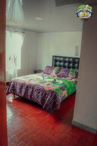 a bed in a room with a red brick floor at Casa Campesina La Fagua in La Calera