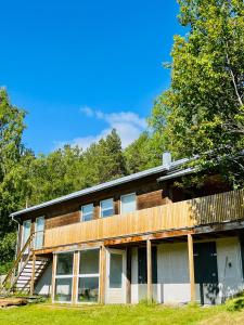 a house with a wooden facade and trees at Skjomen Lodge in Elvegård